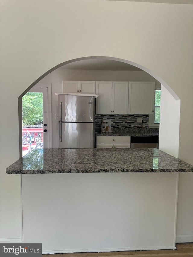 15213 Michigan Rd, Woodbridge, VA 22191 - kitchen featuring appliances with stainless steel finishes, dark stone countertops, tasteful backsplash, and white cabinets