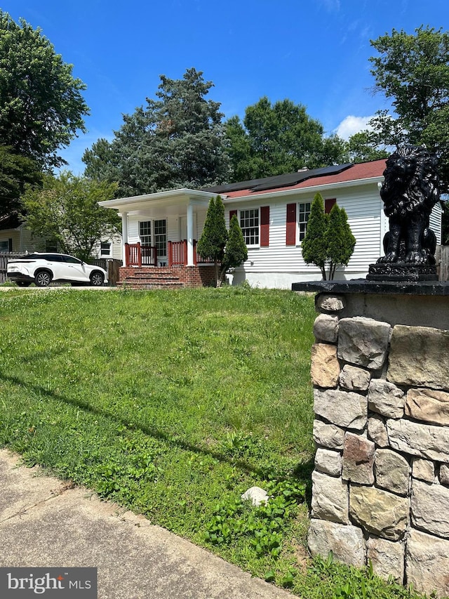 15213 Michigan Rd, Woodbridge, VA 22191 - view of front facade with covered porch, a front yard, and roof mounted solar panels