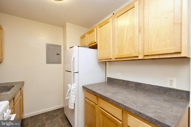 2845 Denver St SE Unit 204, Washington, DC 20020 - kitchen with electric panel, freestanding refrigerator, light brown cabinets, baseboards, and dark countertops