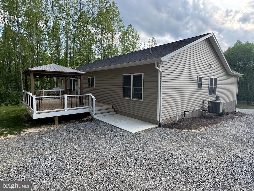 rear view of property featuring a gazebo, central AC, crawl space, a wooden deck, and a shingled roof