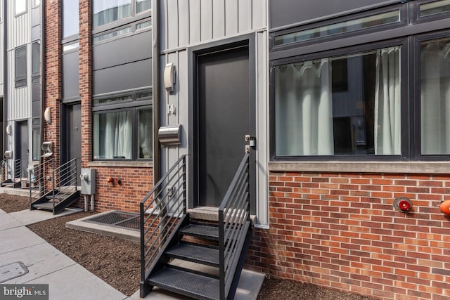 property entrance featuring brick siding and board and batten siding