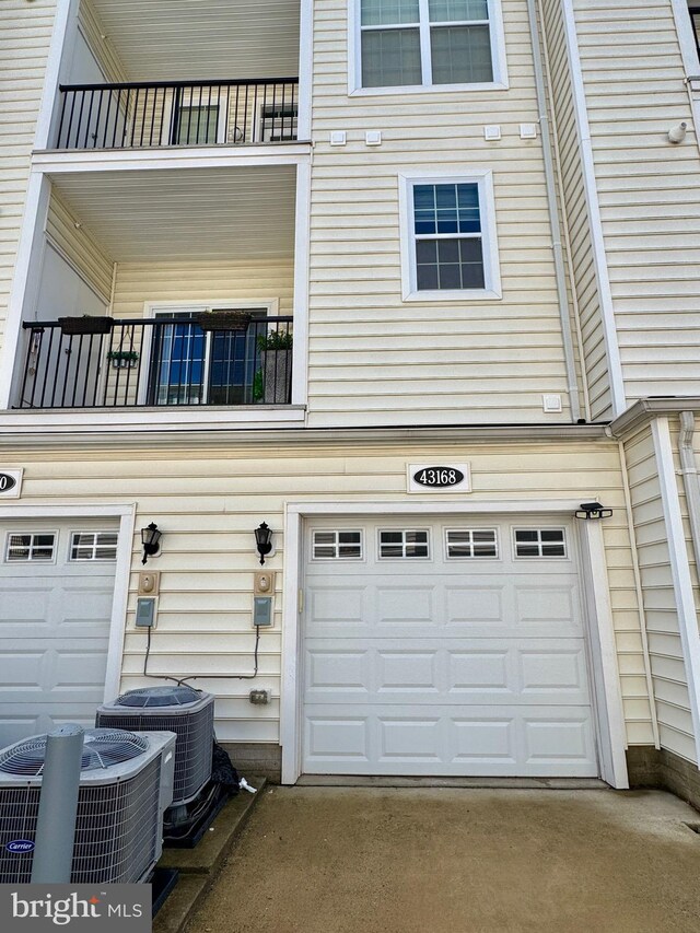 garage with central AC and concrete driveway