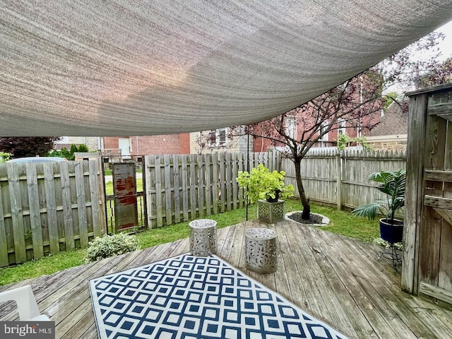 wooden terrace with a fenced backyard