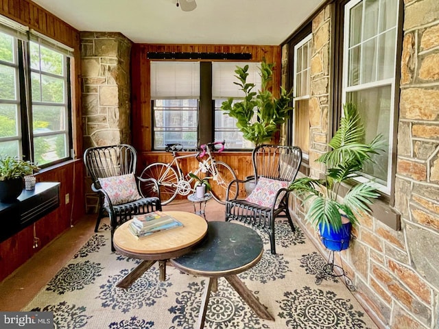 sunroom featuring wood walls and healthy amount of natural light