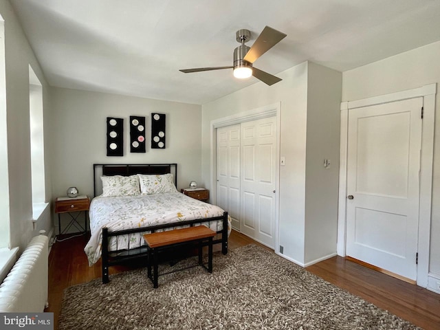 bedroom featuring radiator heating unit, wood finished floors, a closet, and a ceiling fan