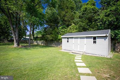 view of yard featuring fence, a storage shed, and an outbuilding