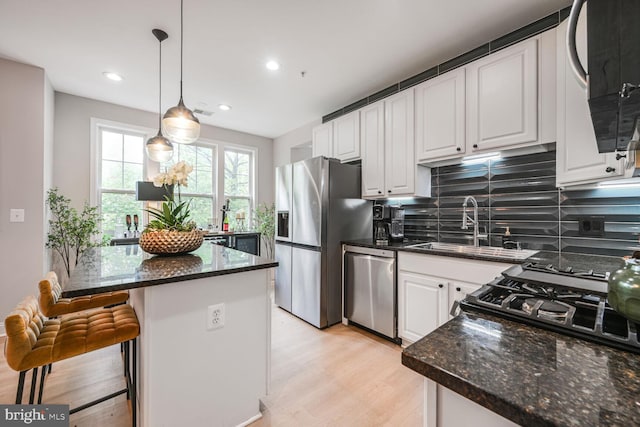 502 King Farm Blvd Unit 202, Rockville, MD 20850 - kitchen with a sink, stainless steel appliances, light wood finished floors, backsplash, and white cabinets