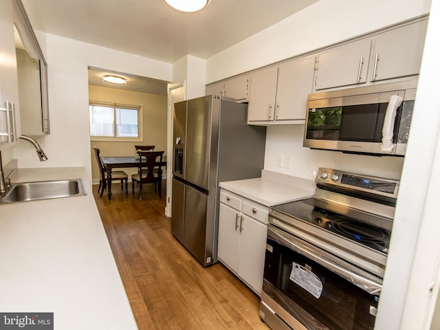 6215 Seminole Pl, College Park, MD 20740 - kitchen with appliances with stainless steel finishes, a sink, light wood-type flooring, light countertops, and gray cabinetry