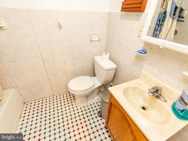 6215 Seminole Pl, College Park, MD 20740 - bathroom featuring tile walls, toilet, vanity, a shower with shower curtain, and a bath