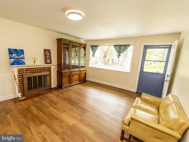 6215 Seminole Pl, College Park, MD 20740 - living area featuring wood finished floors, healthy amount of natural light, a brick fireplace, and baseboards