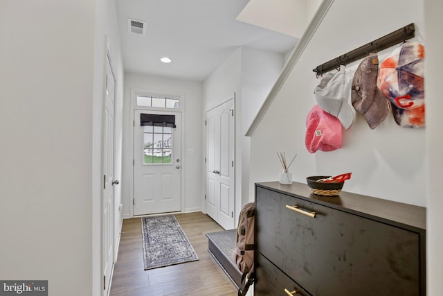 entryway with wood finished floors, recessed lighting, and baseboards