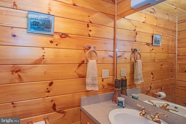 bathroom with vanity and wooden walls
