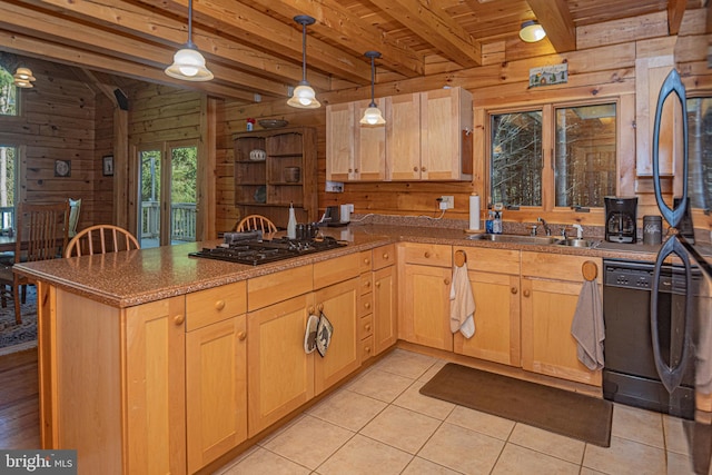 kitchen featuring wooden walls, light brown cabinetry, a peninsula, and a sink