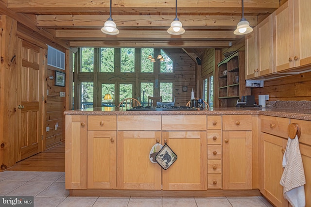 kitchen with beamed ceiling, wooden walls, and light brown cabinetry