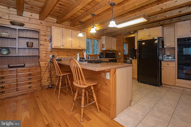 kitchen featuring a peninsula, beam ceiling, black appliances, wooden walls, and wood ceiling