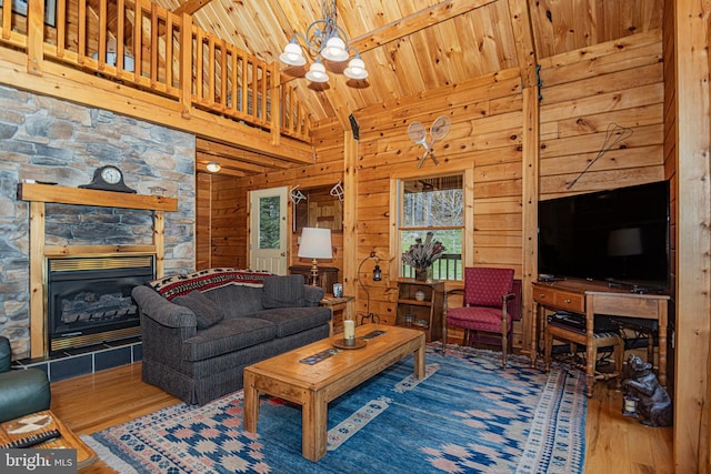 living room featuring wood walls, an inviting chandelier, wood ceiling, and wood finished floors