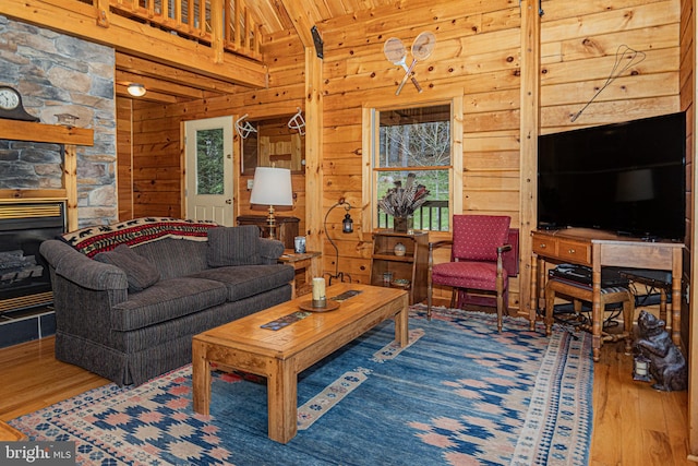 living area featuring lofted ceiling, wood walls, wooden ceiling, and wood finished floors