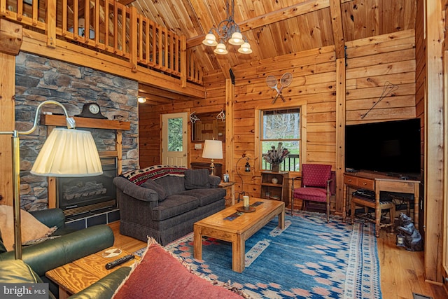 living area featuring a chandelier, wooden walls, and wood finished floors