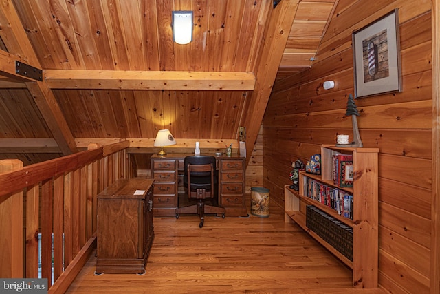 office area with wooden walls, wood ceiling, light wood-style flooring, and vaulted ceiling with beams