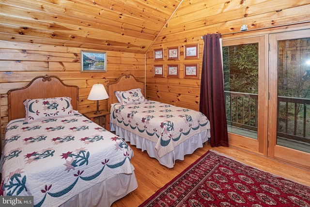 bedroom with wood ceiling, wood finished floors, access to outside, wooden walls, and vaulted ceiling