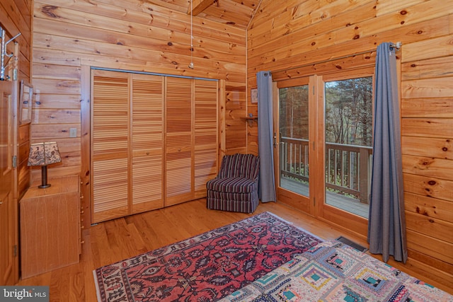 unfurnished room with visible vents, wood finished floors, and wooden walls