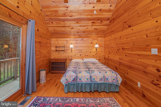 bedroom featuring wood ceiling, wood finished floors, wood walls, visible vents, and vaulted ceiling