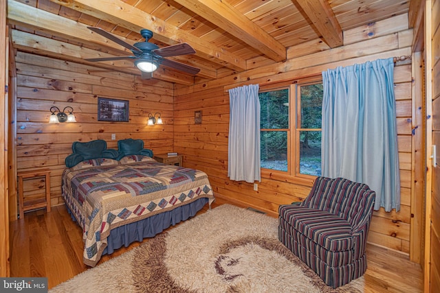 bedroom featuring wood walls, wood finished floors, visible vents, wooden ceiling, and beamed ceiling