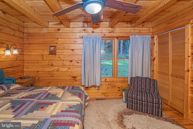 bedroom with wood walls, beam ceiling, and wood ceiling