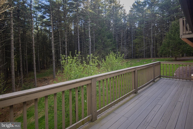 wooden deck featuring a forest view