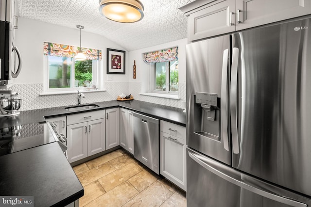 kitchen featuring appliances with stainless steel finishes, dark countertops, a sink, backsplash, and an ornate ceiling