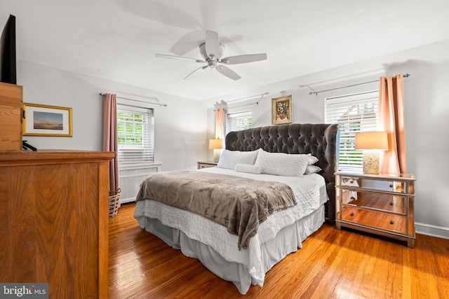bedroom with wood finished floors, baseboards, and ceiling fan
