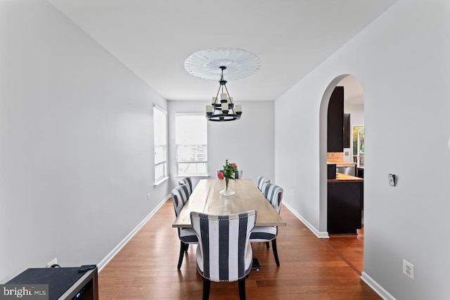 5971 Schooner Cir, King George, VA 22485 - dining space featuring arched walkways, wood finished floors, a chandelier, and baseboards