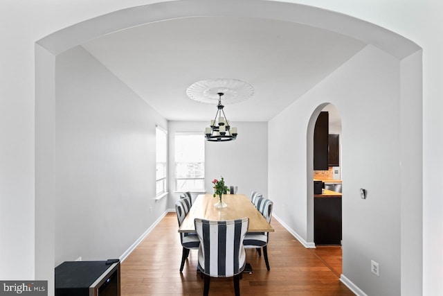 5971 Schooner Cir, King George, VA 22485 - dining area with wood finished floors, arched walkways, baseboards, and a chandelier