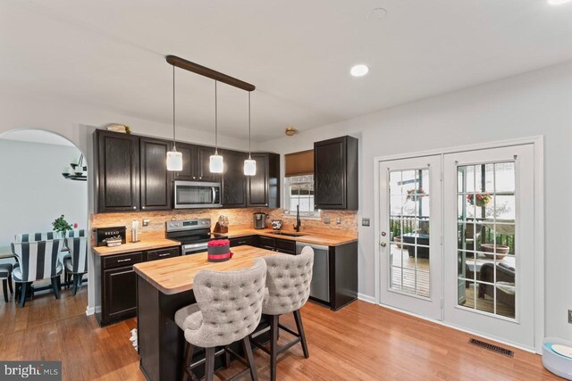 5971 Schooner Cir, King George, VA 22485 - kitchen featuring stainless steel appliances, wooden counters, tasteful backsplash, arched walkways, and recessed lighting