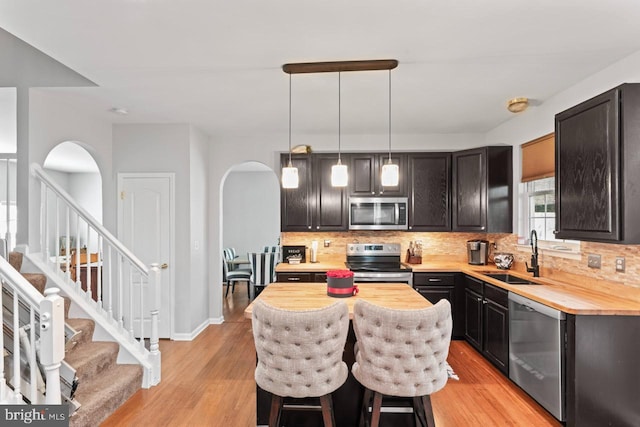 5971 Schooner Cir, King George, VA 22485 - kitchen featuring a sink, stainless steel appliances, arched walkways, and decorative backsplash