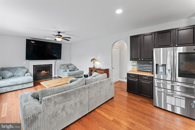 5971 Schooner Cir, King George, VA 22485 - living room featuring arched walkways, ceiling fan, a lit fireplace, light wood-style floors, and recessed lighting