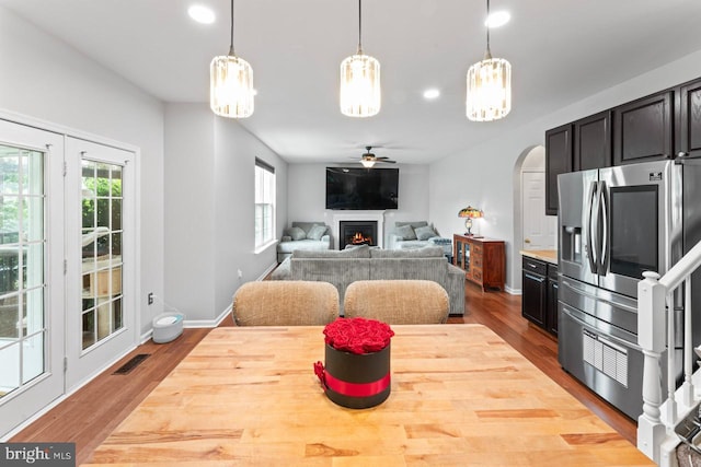 5971 Schooner Cir, King George, VA 22485 - dining area with wood finished floors, arched walkways, a warm lit fireplace, ceiling fan, and recessed lighting