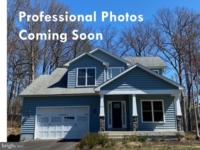 craftsman inspired home with a porch, roof with shingles, a garage, and driveway