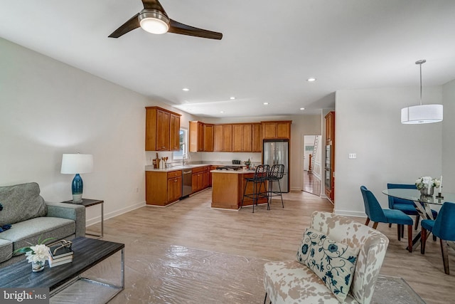 living area with a ceiling fan, baseboards, recessed lighting, and light wood-type flooring