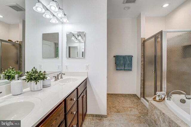 bathroom featuring a shower stall, a bath, and double vanity