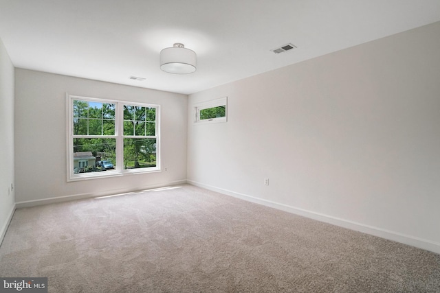 carpeted spare room featuring healthy amount of natural light and baseboards