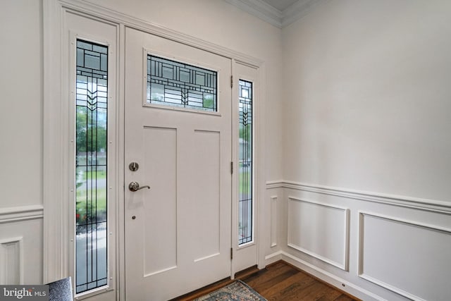 foyer entrance featuring a decorative wall, ornamental molding, plenty of natural light, dark wood-type flooring, and wainscoting