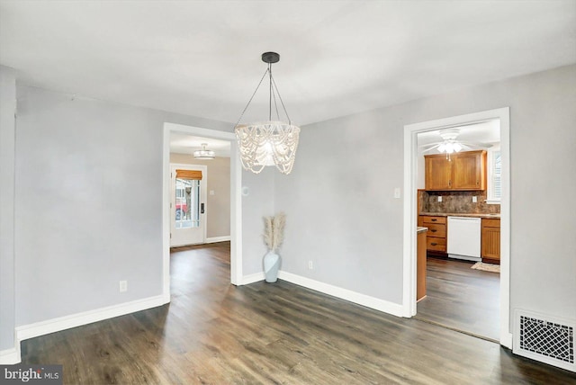 unfurnished dining area featuring baseboards, ceiling fan with notable chandelier, visible vents, and dark wood-type flooring