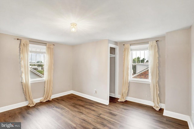 empty room with wood finished floors and baseboards