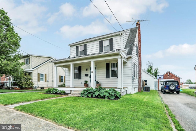 bungalow with a porch, a chimney, central AC unit, and a front yard
