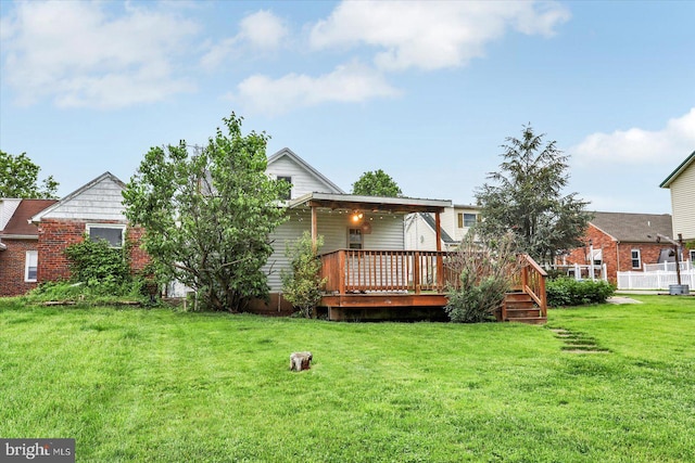 back of house with a lawn and a deck