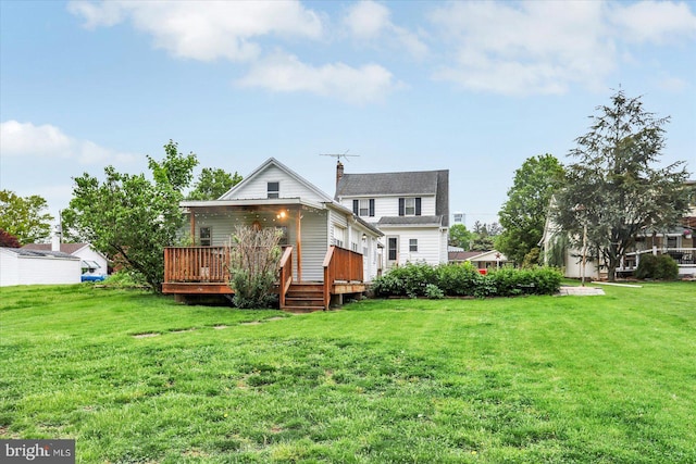back of property with a yard, a deck, and a chimney