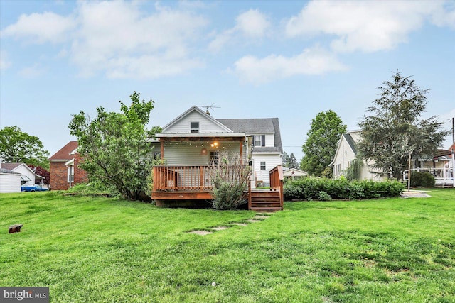 back of house featuring a lawn and a wooden deck