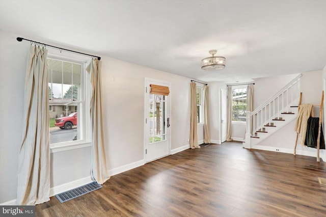 entrance foyer with visible vents, wood finished floors, baseboards, and stairs
