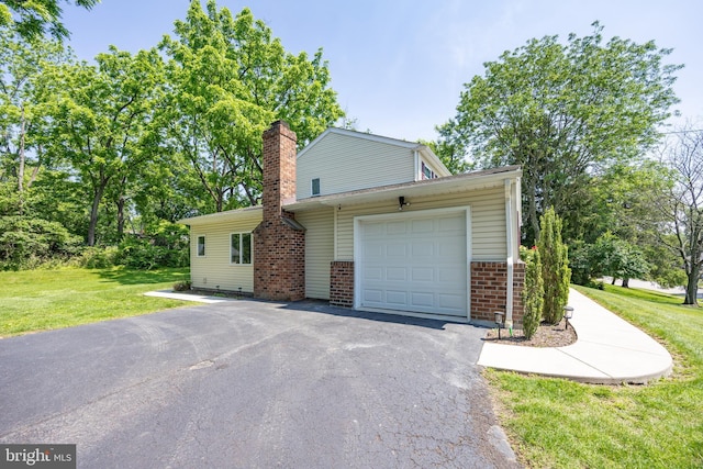 926 Pierce Rd, Norristown, PA 19403 - view of home's exterior featuring a garage, driveway, a lawn, brick siding, and a chimney
